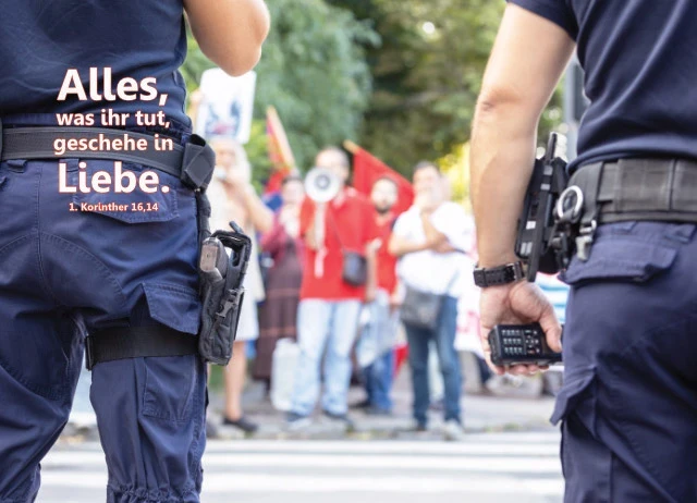 Banner Jahreslosung 2024 -Polizisten und Demonstranten