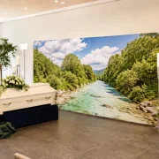 Große Zipper-Wall mit Fluss-Isar-Motiv in einer modernen Trauerhalle. Die 400 × 230 cm breite Premium-Rückwand bildet einen stilvollen Hintergrund für eine würdevolle Trauerfeier.