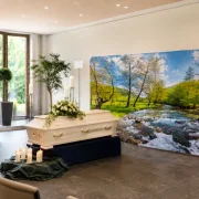 Eine tröstliche dekorierte Trauerhalle mit Sarg vor einem Zpper-Display und Blumenschmuck