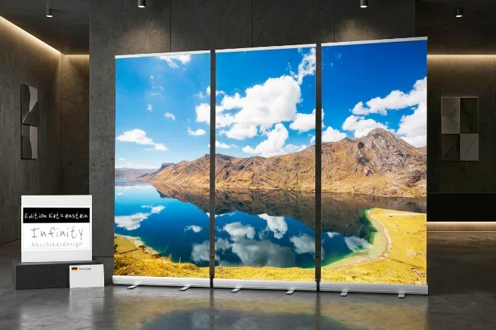 Eine weitläufige Andenlandschaft mit markanter Gebirgskette unter blauem Himmel. Im Vordergrund spiegelt ein glasklarer, tiefblauer See die Berge und Wolken fast vollkommen wider. Sanfte Uferzonen mit grün-gelblichen Farbtönen verleihen dem Motiv eine friedvolle Natürlichkeit.