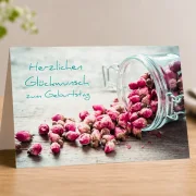 Hochwertiges Produktfoto der christlichen Klappkarte DIN A6 „Herzlichen Glückwunsch zum Geburtstag“ von Edition Katzenstein mit Rosenblüten in einem Glasgefäß.