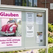 Christliches DIN A2 Poster Glauben von Corrie ten Boom mit rotem VW Käfer in einer bunten Altstadt-Straße