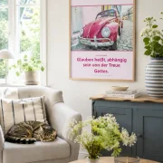 Christliches DIN-A2-Hochformat-Poster „Glauben“ mit himbeerfarbenem VW Käfer und Zitat von Corrie ten Boom in einem hellen dänisch-skandinavischen Wohnzimmer. Eine getigerte Hauskatze schläft entspannt auf einem Sessel.