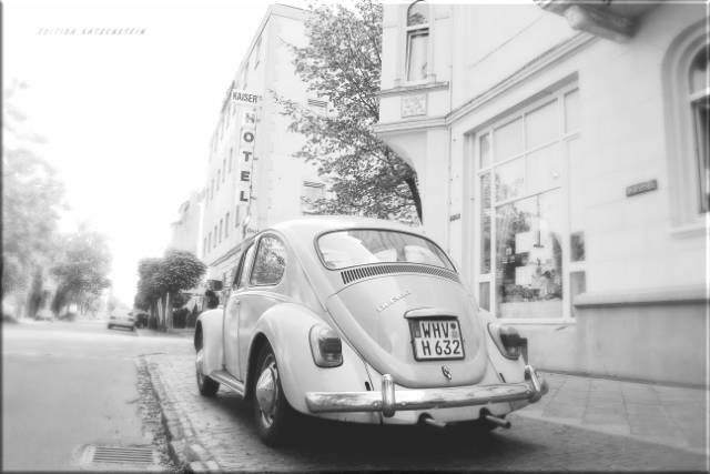 Leinwanddruck: Weißer VW Käfer auf Bürgersteig