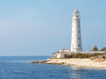 Leinwanddruck Weißer Leuchtturm mit Nebengebäuden