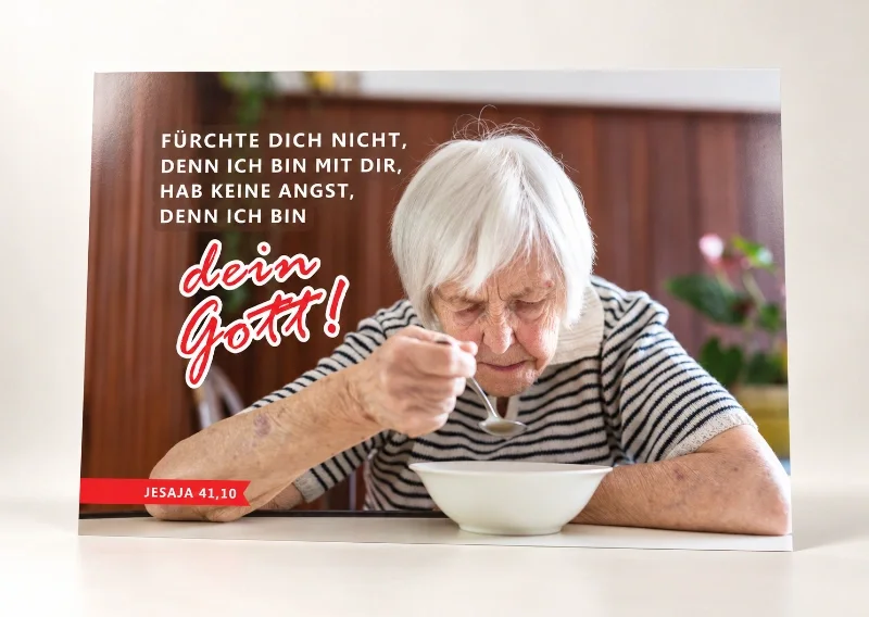 Du bist nicht allein – DIN-A1-Poster zur Jahreslosung 2027 Poster Jahreslosung 2027 DIN A1 mit älterer Frau allein am Tisch