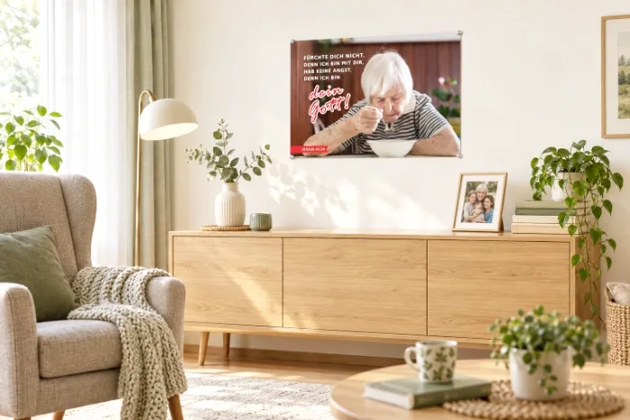 Poster Jahreslosung 2027 A2 - Gottes Zusage für den Alltag DIN-A2-Poster zur Jahreslosung 2027 im hellen Wohnzimmer einer älteren Person