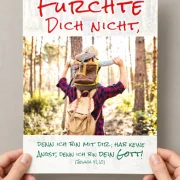 Zwei Hände halten das DIN-A4-Poster zur Jahreslosung 2027 mit dem Motiv „Vater trägt Sohn auf Schultern“