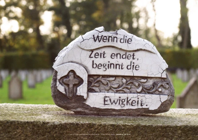 Keramische Figur auf verwittertem Grabstein aus der Nähe aufgenommen.