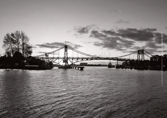 Poster A1 - Bestatterbedarf - Große Stahlbrücke im Gegenlicht mit hellem Himmel.