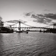 Poster A1 - Bestatterbedarf - Große Stahlbrücke im Gegenlicht mit hellem Himmel.