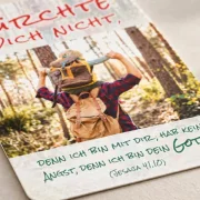 Detailansicht der Postkarte zur Jahreslosung 2027 mit Vater und Kind im Wald sowie dem Bibelvers aus Jesaja 41,10
