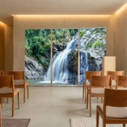 Drei Roll-Up-Displays mit einem Wasserfall-Motiv stehen nebeneinander in einer modernen Trauerhalle mit Holzstühlen und heller Wandgestaltung.